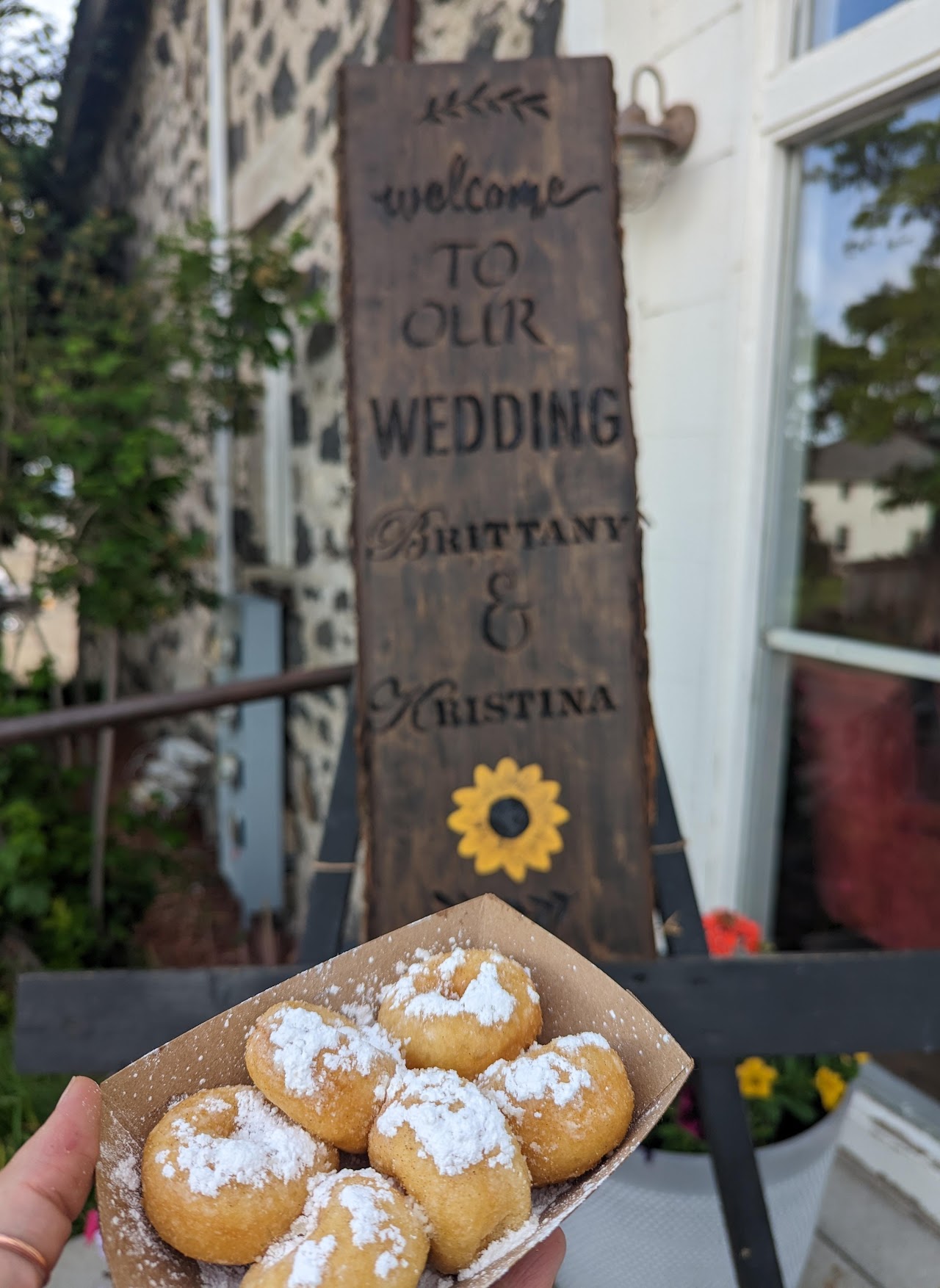 Donuts held in front of a sign